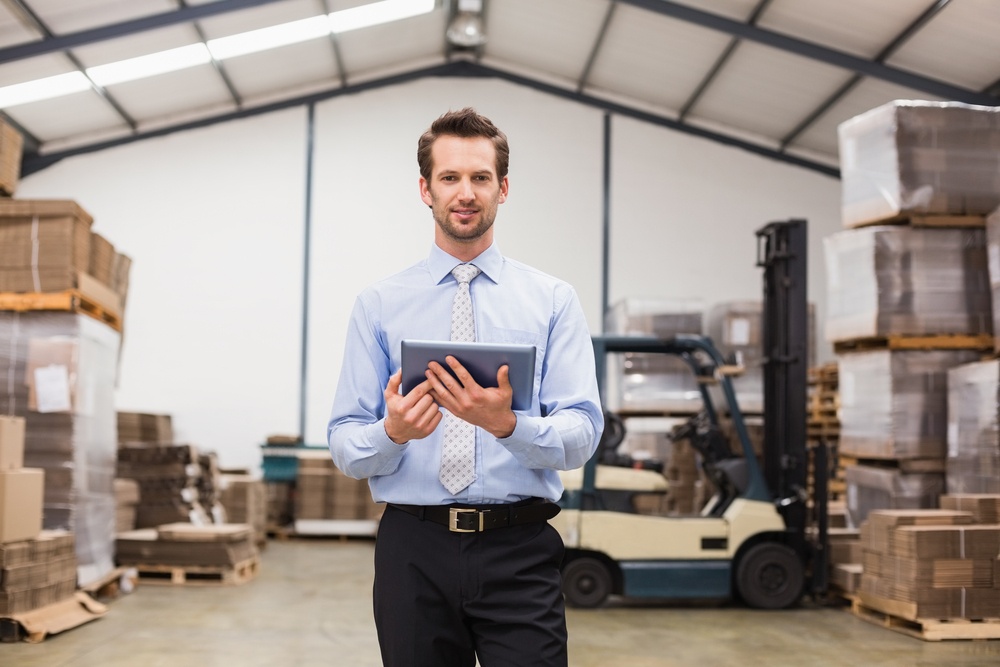 Portrait of male manager using digital tablet in warehouse